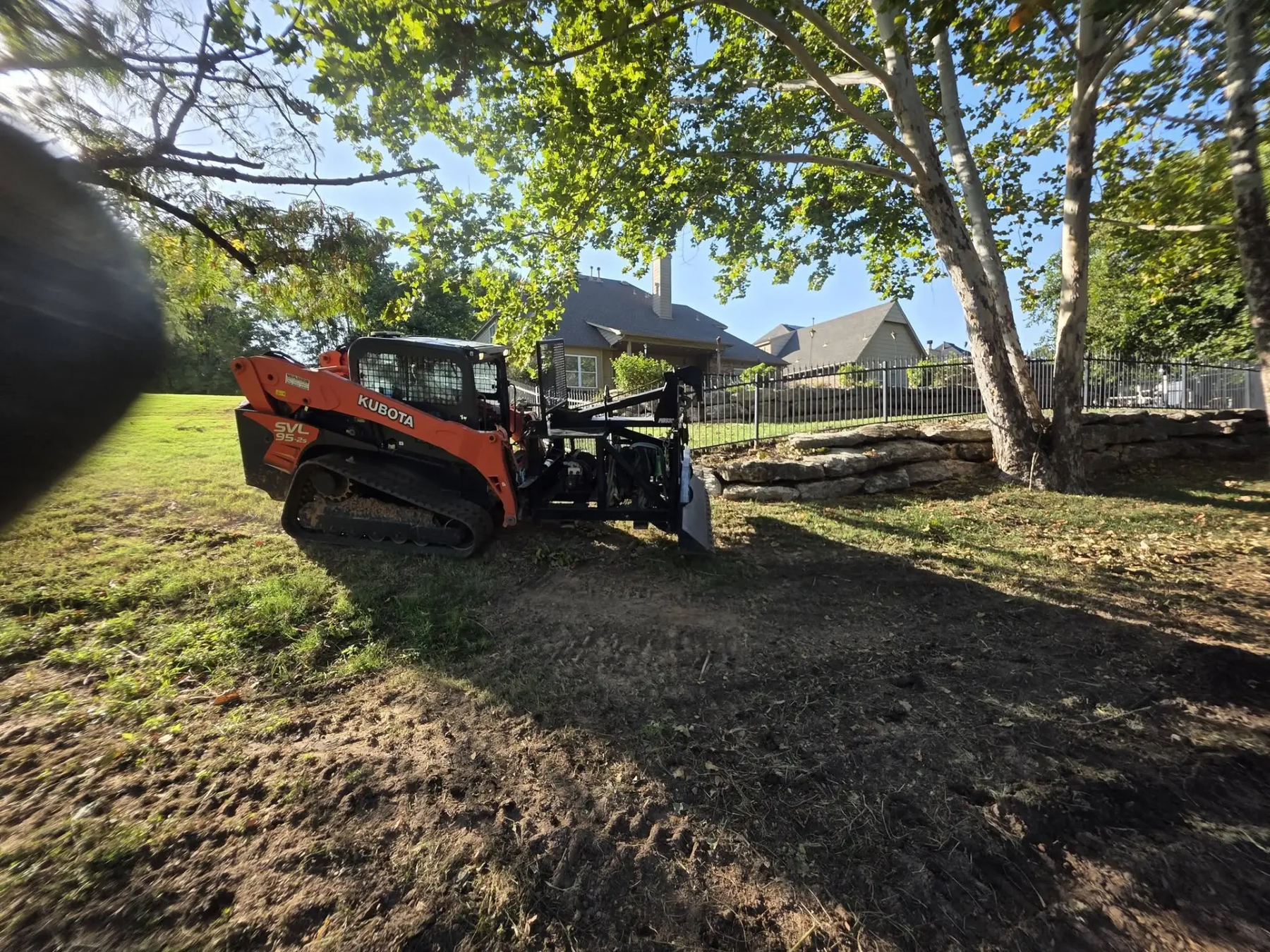 Kubota SVL95 track loader grading a residential back yard