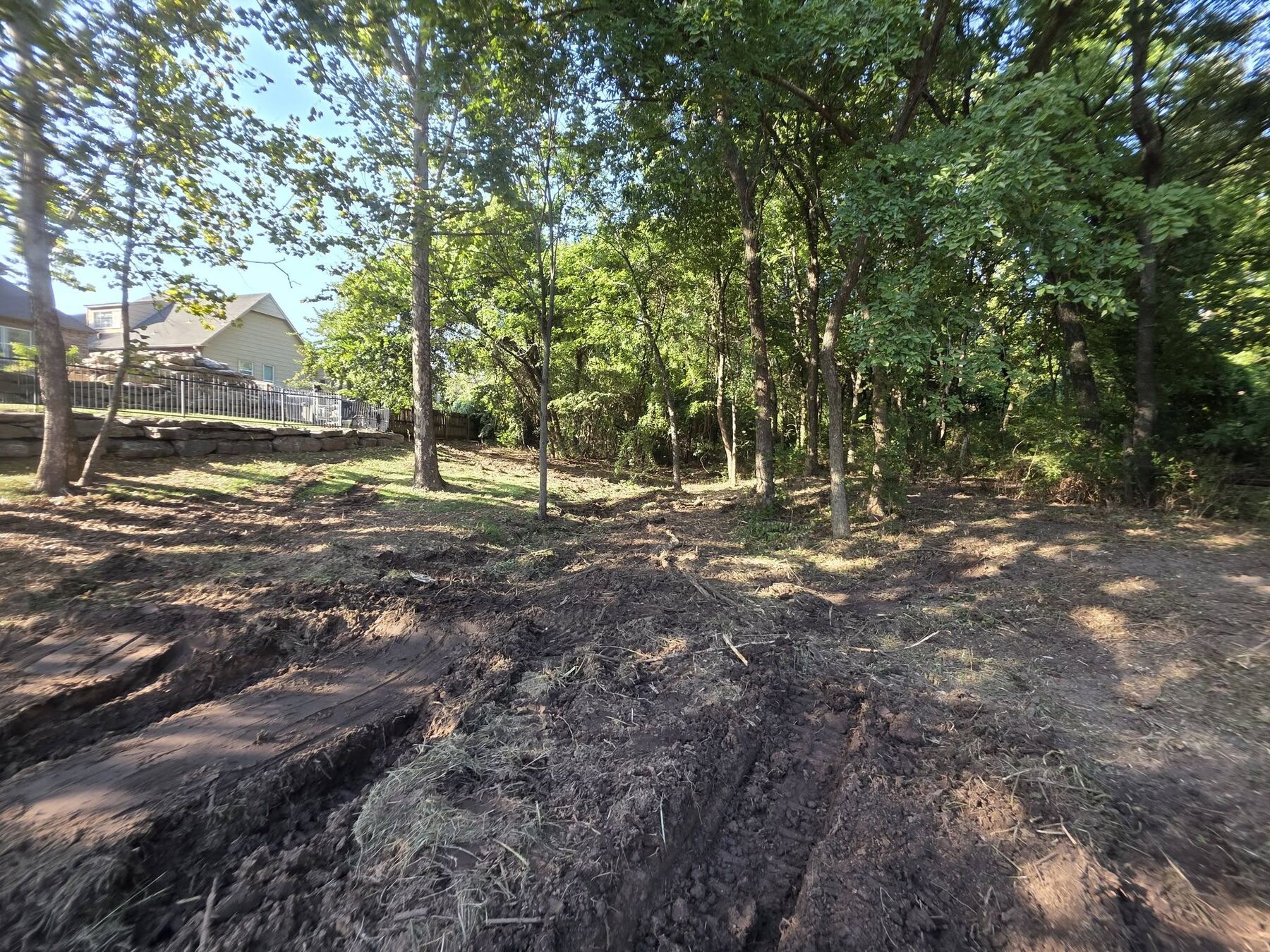 Dirt work and soil shaping alongside a residential home lot